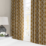Curtains made from a printed linen fabric sample in orange, blue and off white featuring a stylized fern pattern.