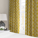 Curtains made from a printed linen fabric sample in yellow, blue and off white featuring a stylized fern pattern.