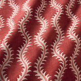 A printed linen fabric sample in red and pink featuring a stylized fern pattern.