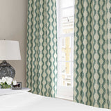 Curtains made from a printed linen fabric sample in blue and off white featuring a stylized fern pattern.