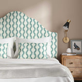 Headboard upholstered in a printed linen fabric sample in blue and off white featuring a stylized fern pattern.