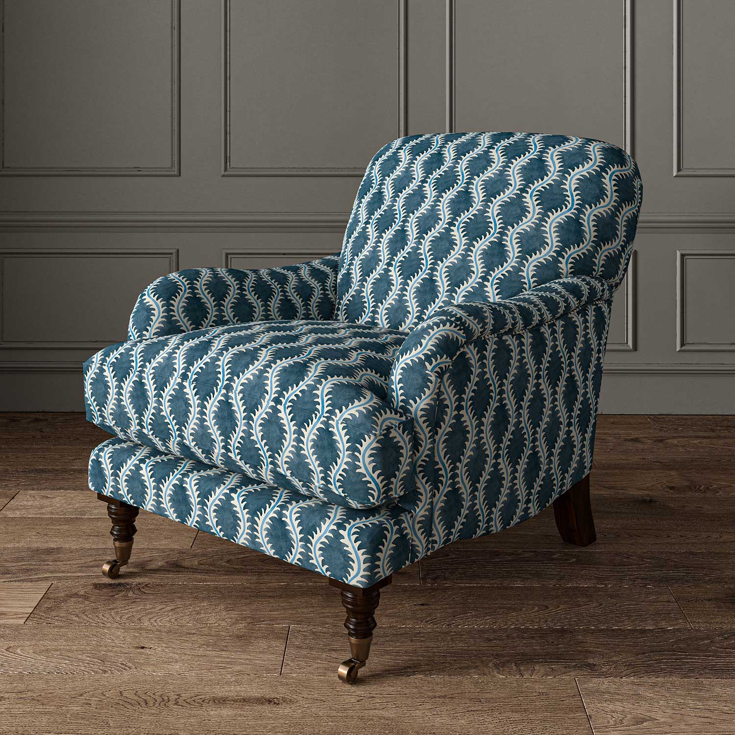 Chair upholstered in a printed linen fabric in blue and off white featuring a stylized fern pattern.