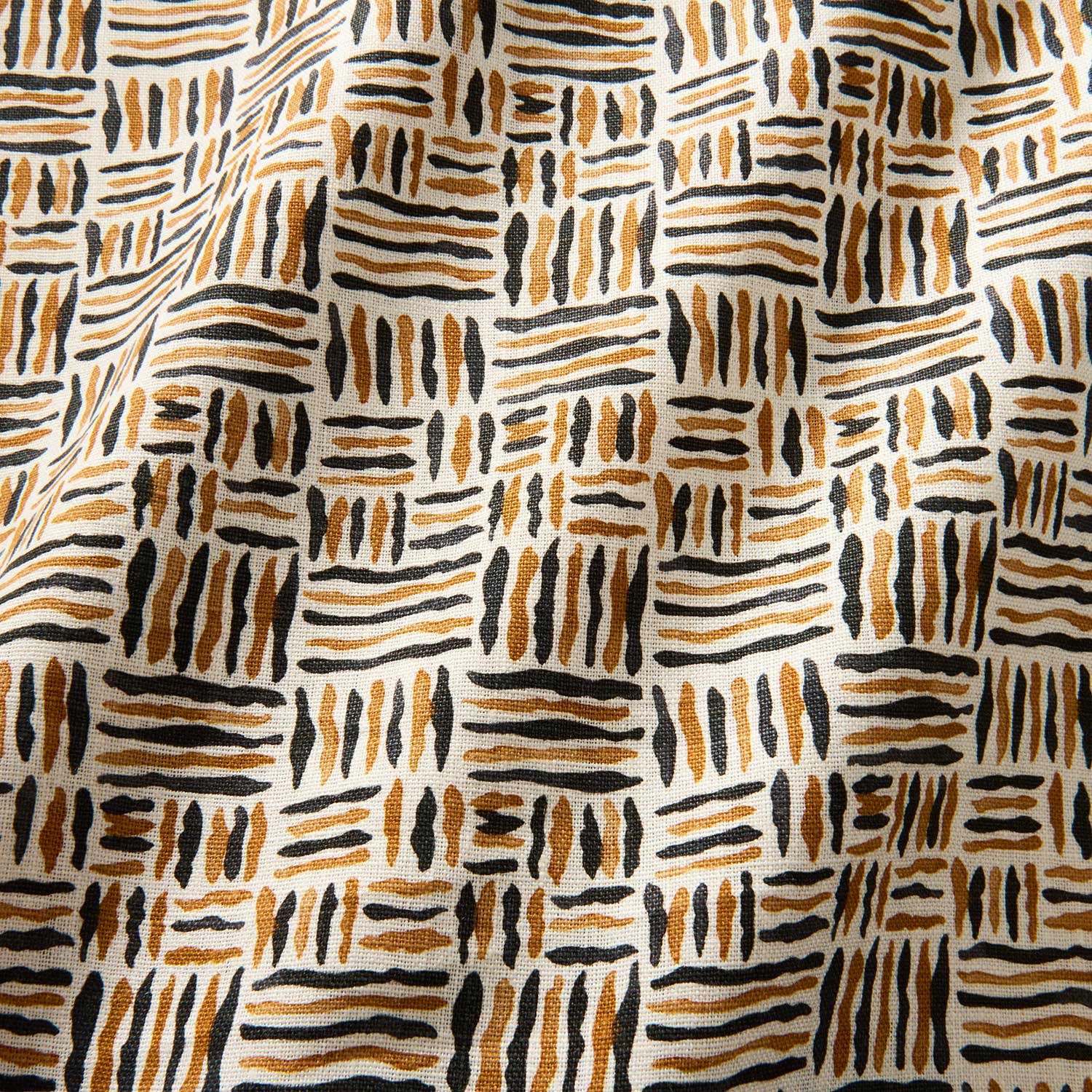 A printed linen fabric sample in black, orange and off white featuring a basketweave pattern.
