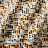 A printed linen fabric sample in black, orange and off white featuring a basketweave pattern.