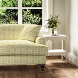 Sofa upholstered in a printed linen fabric in yellow and off white featuring a basketweave pattern.