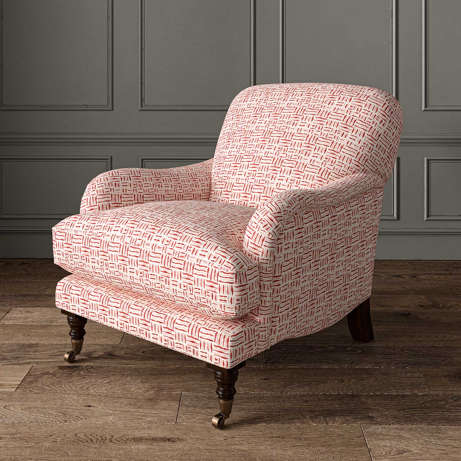 Chair upholstered in a printed linen fabric in red, pink and off white featuring a basketweave pattern.