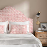 Headboard upholstered in a printed linen fabric in red, pink and off white featuring a basketweave pattern.