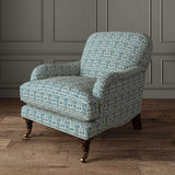 Chair upholstered in a printed linen fabric in blue and off white featuring a basketweave pattern.