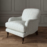 Chair upholstered in a printed linen fabric in blue and off white featuring a basketweave pattern.