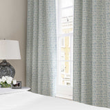 Curtains made from a printed linen fabric in blue and off white featuring a basketweave pattern.