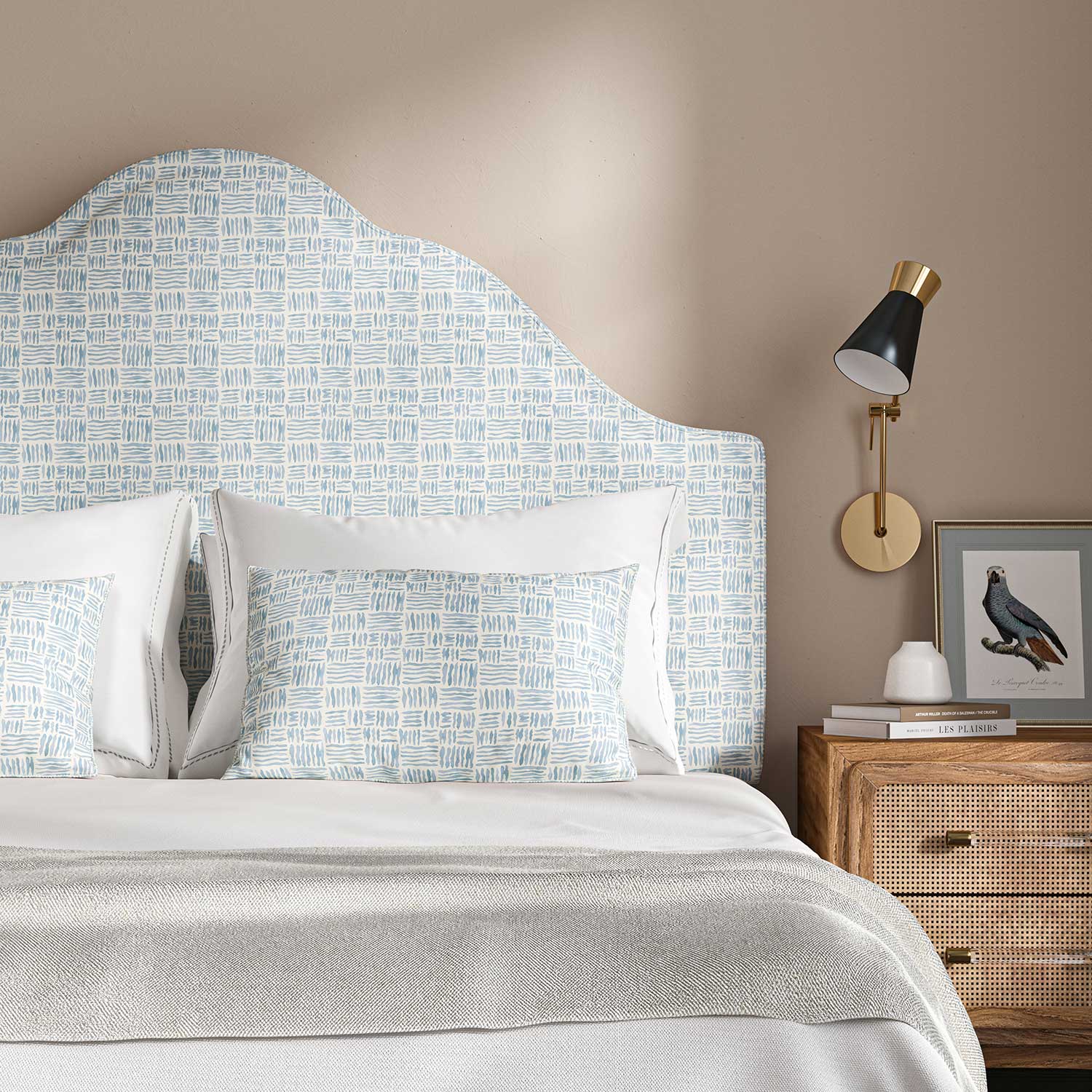 Headboard upholstered in a printed linen fabric in blue and off white featuring a basketweave pattern.