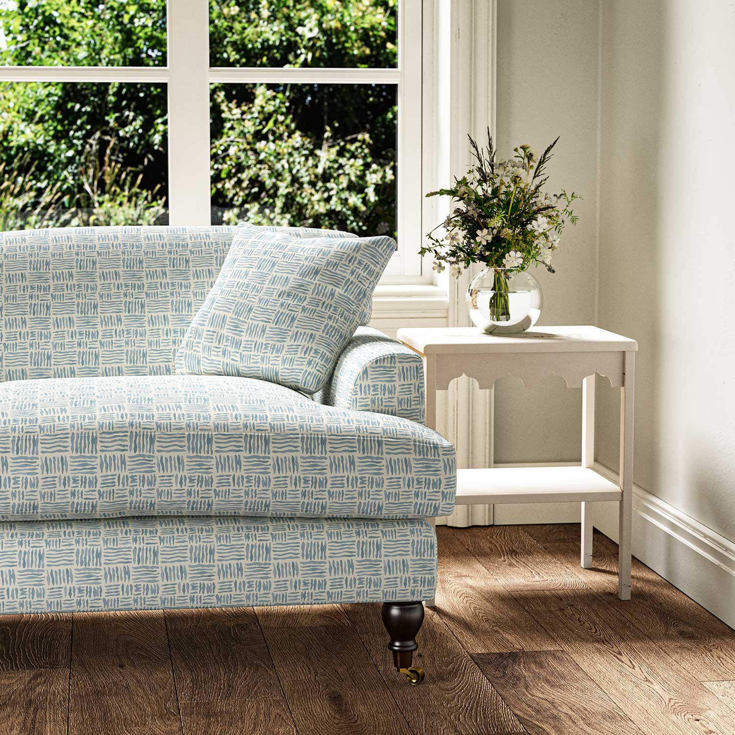 Sofa upholstered in a printed linen fabric in blue and off white featuring a basketweave pattern.