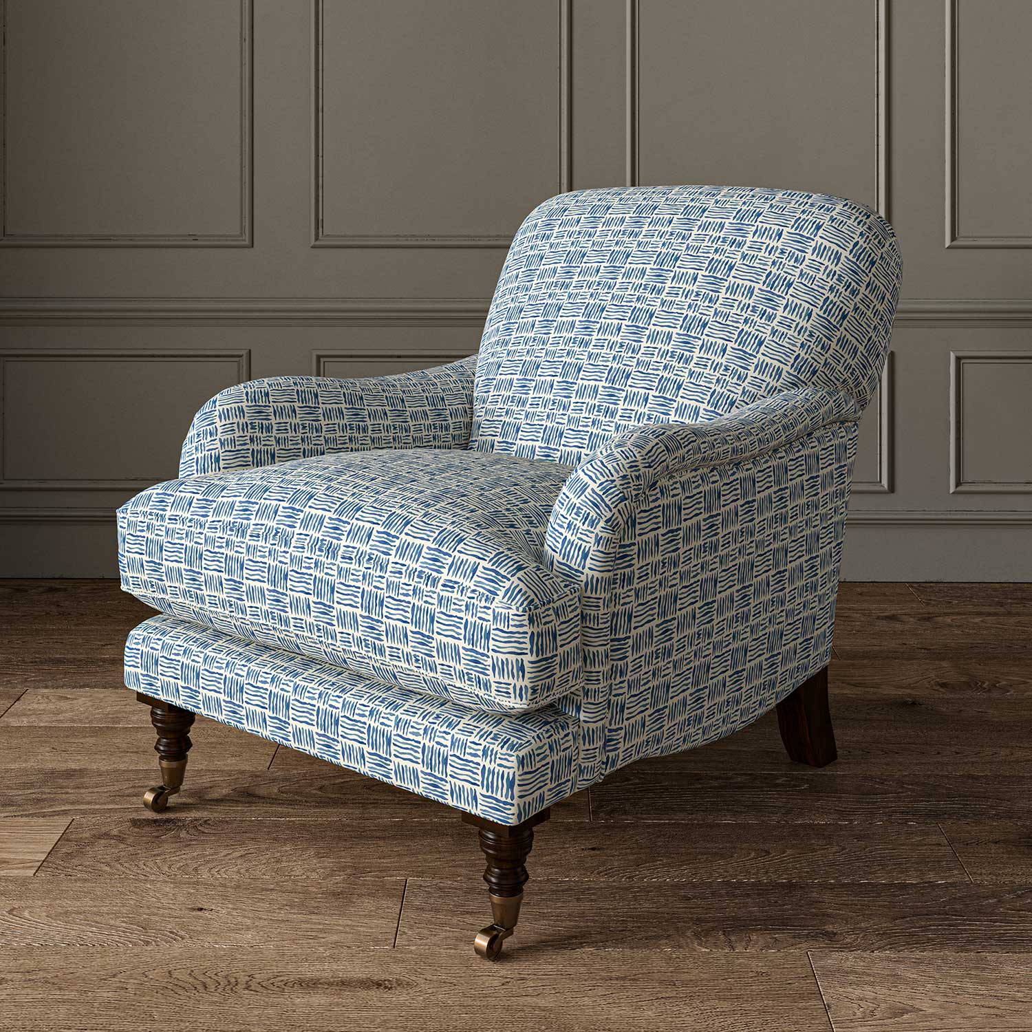 Chair upholstered in a printed linen fabric in blue and off white featuring a basketweave pattern.
