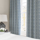 Curtains made from a printed linen fabric in blue and off white featuring a basketweave pattern.