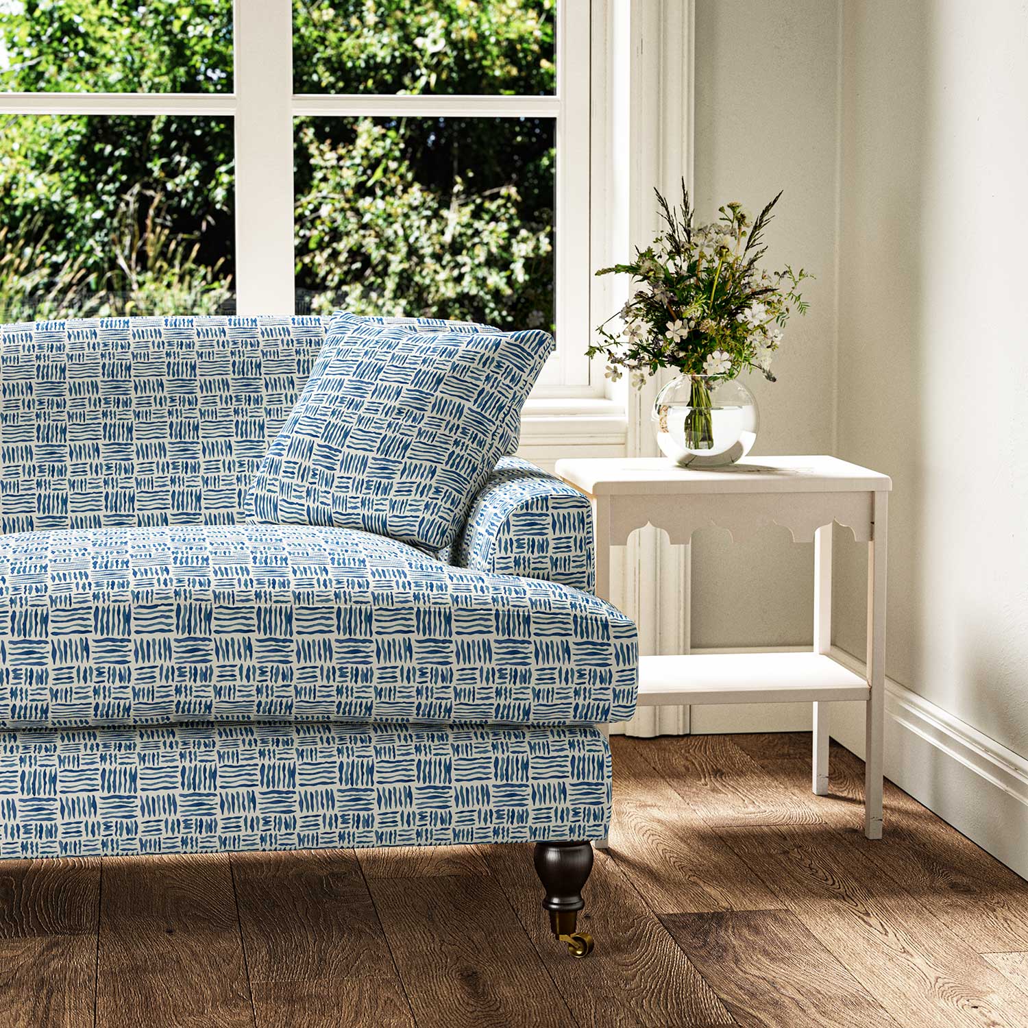 Sofa upholstered in a printed linen fabric in blue and off white featuring a basketweave pattern.