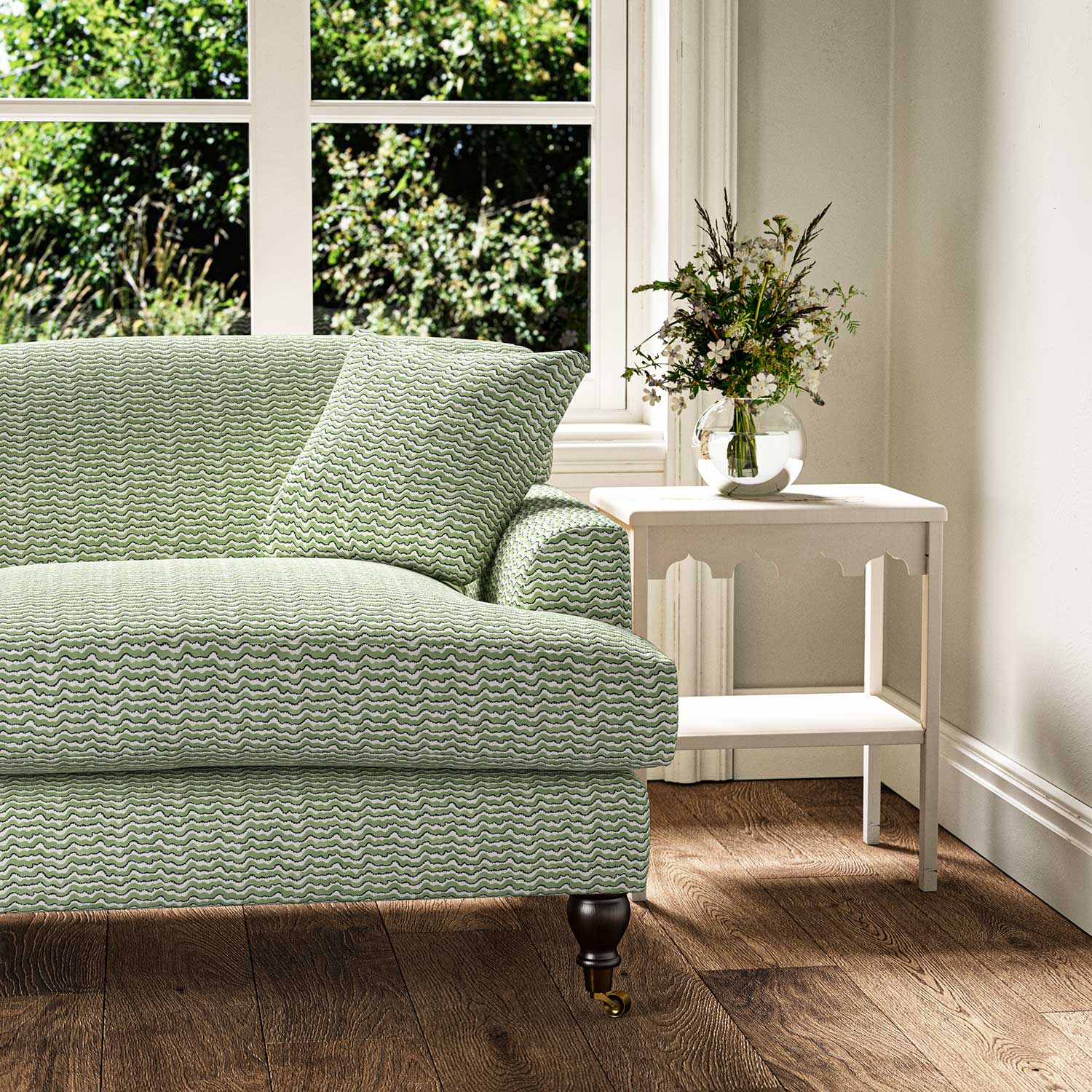Sofa upholstered in a printed linen fabric in green, black and off white featuring a sound wave pattern