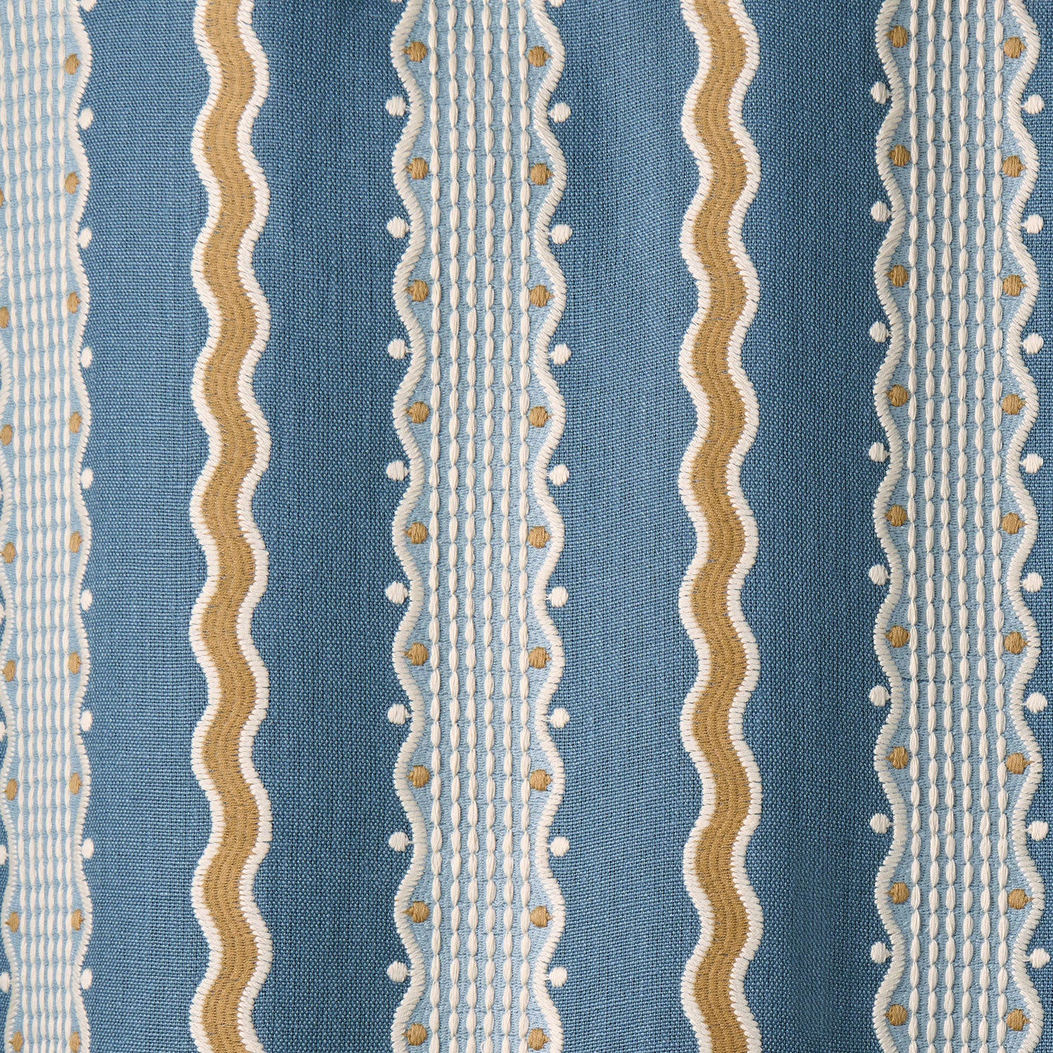 Embroidery fabric with blue, beige, and white stripes on a blue background.