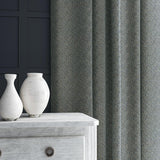 Curtain in blue and off-white woven fabric featuring a herringbone pattern.