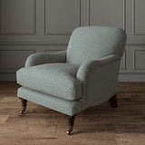 Chair upholstered in a blue and off-white woven fabric featuring a trellis pattern.