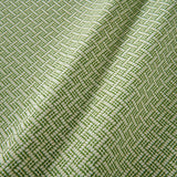 A woven fabric sample in green and off-white featuring a trellis pattern.