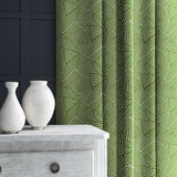 Curtain in green and off-white woven fabric featuring a geometric pattern.