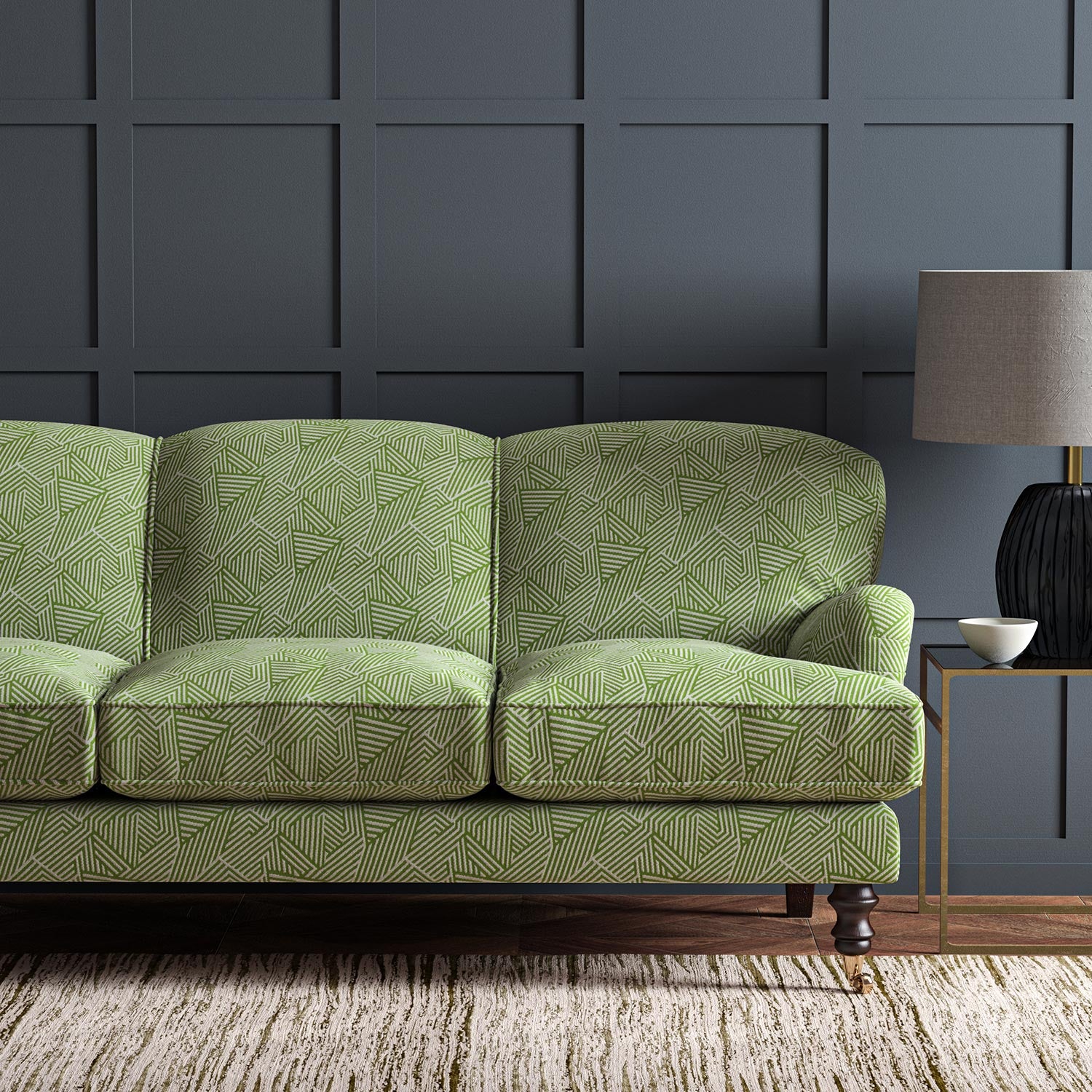 Sofa upholstered in a green and off-white woven fabric featuring a geometric pattern.