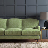 Sofa upholstered in a green and off-white woven fabric featuring a geometric pattern.