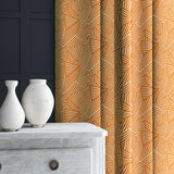 Curtain in orange and off-white woven fabric featuring a geometric pattern.