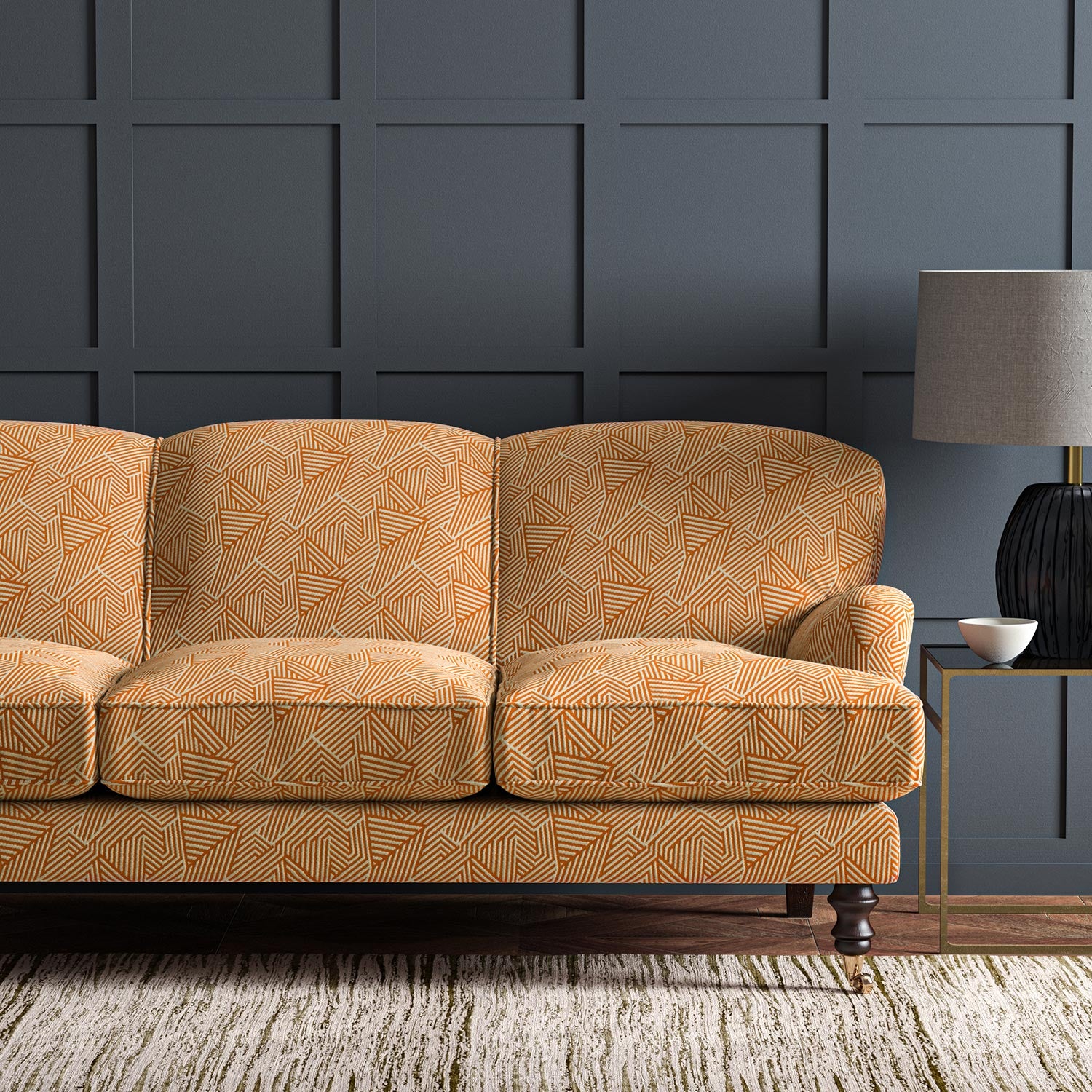 Sofa upholstered in a orange and off-white woven fabric featuring a geometric pattern.