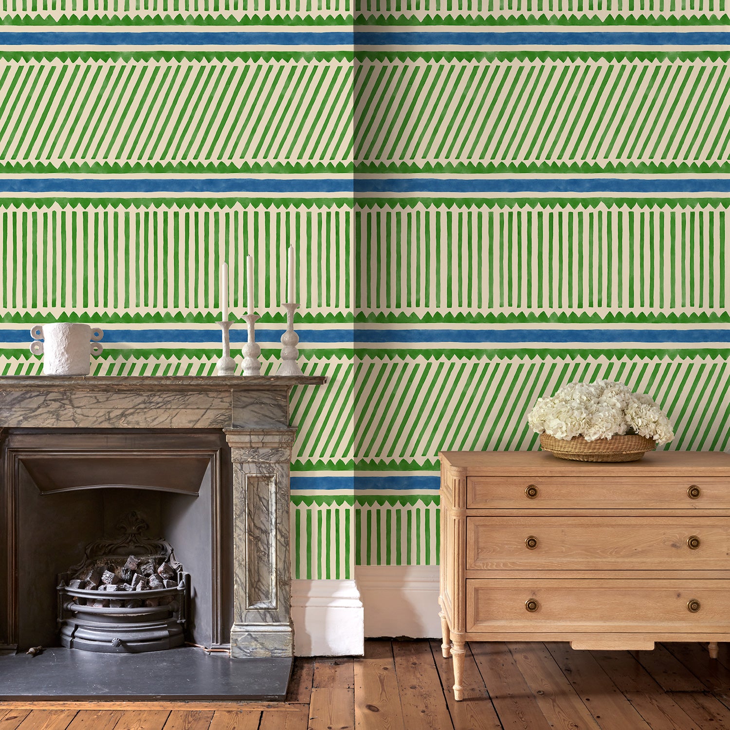 Sitting room with a playful green and blue wallpaper with a combination of tonal stripes, zigzags, and matching colour bands.