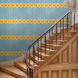 Hall with a chain-link wallpaper with different-sized blue and yellow stripes.