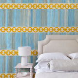 Bedroom with a chain-link wallpaper with different-sized blue and yellow stripes.