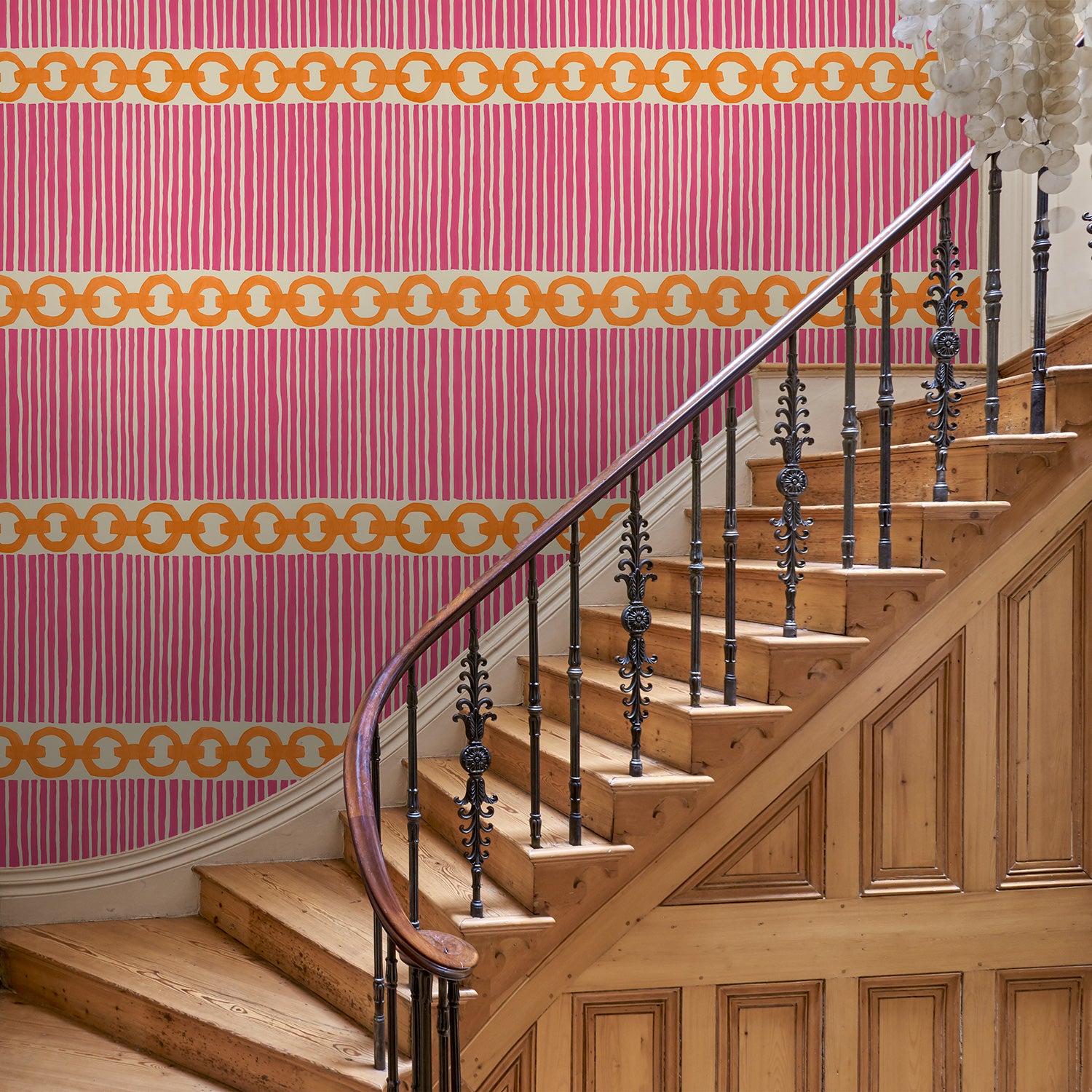 Hall with a chain-link wallpaper with different-sized orange and pink stripes.
