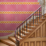 Hall with a chain-link wallpaper with different-sized orange and pink stripes.