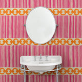 Cloakroom with a chain-link wallpaper with different-sized orange and pink stripes.