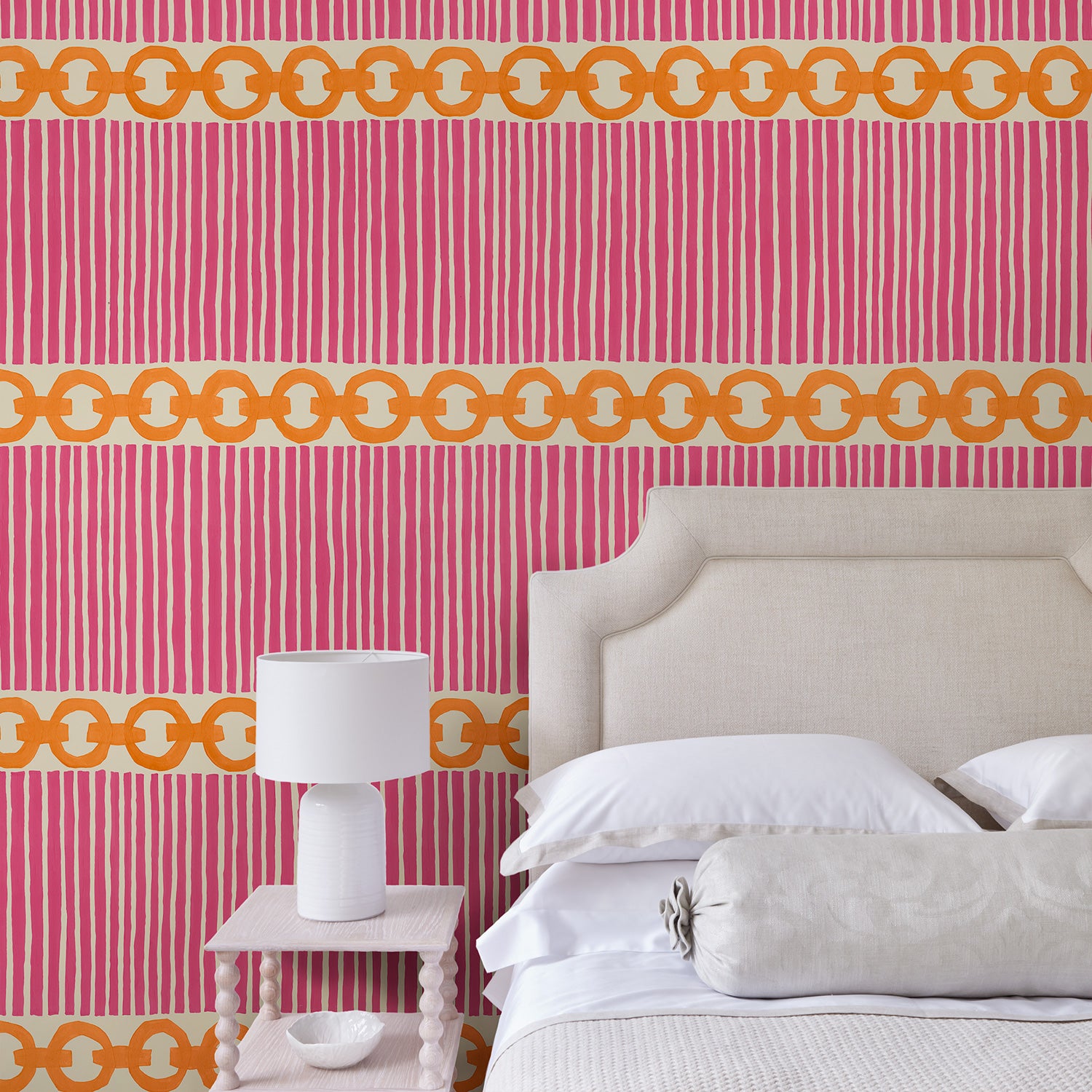 Bedroom with a chain-link wallpaper with different-sized orange and pink stripes.