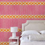 Bedroom with a chain-link wallpaper with different-sized orange and pink stripes.