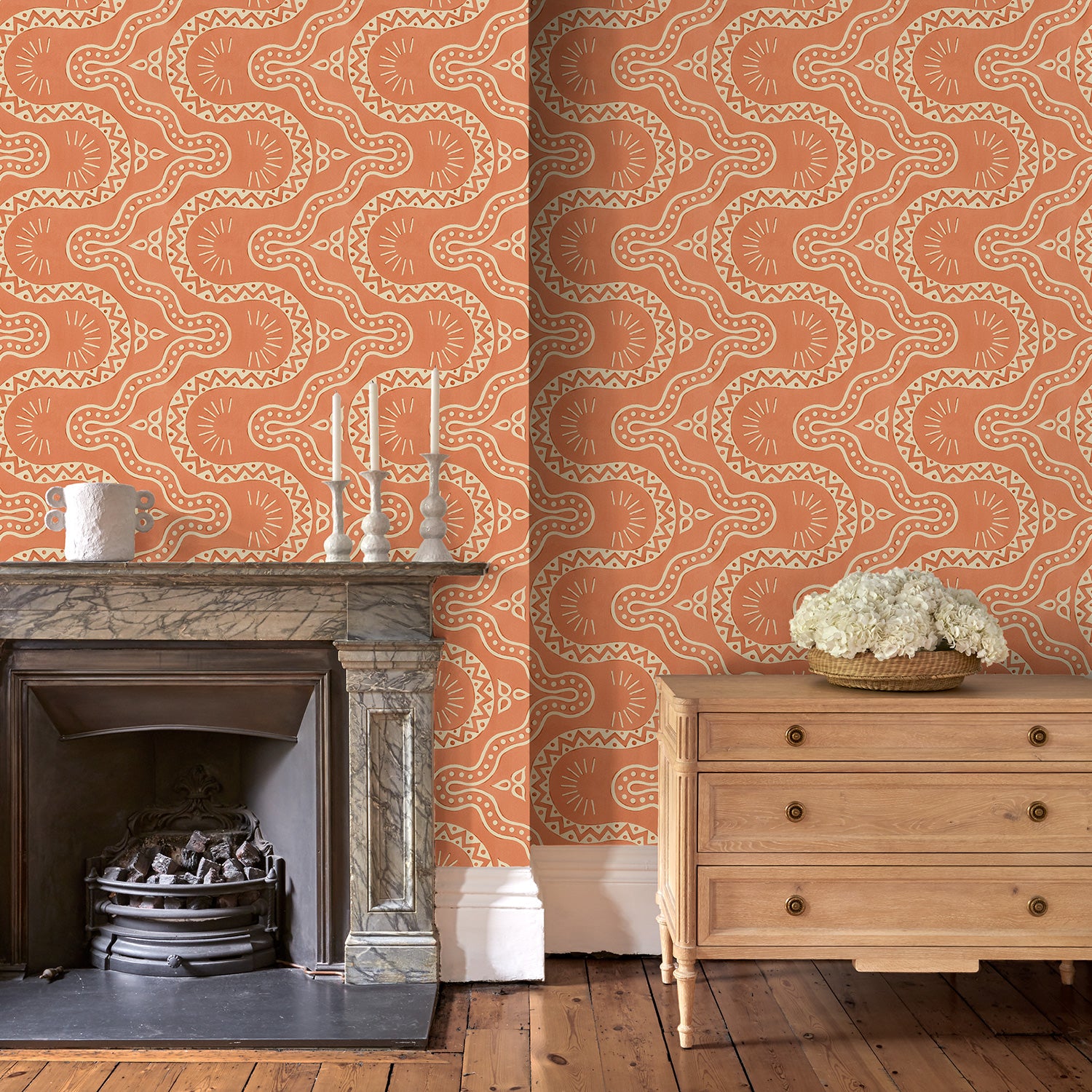 Sitting room with a orange geometric wallpaper.