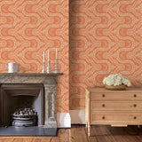 Sitting room with a orange geometric wallpaper.