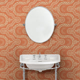 Cloakroom with a orange geometric wallpaper.