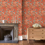 Sitting room with a tropical wallpaper in chilli showcasing beautiful botanicals and butterflies.