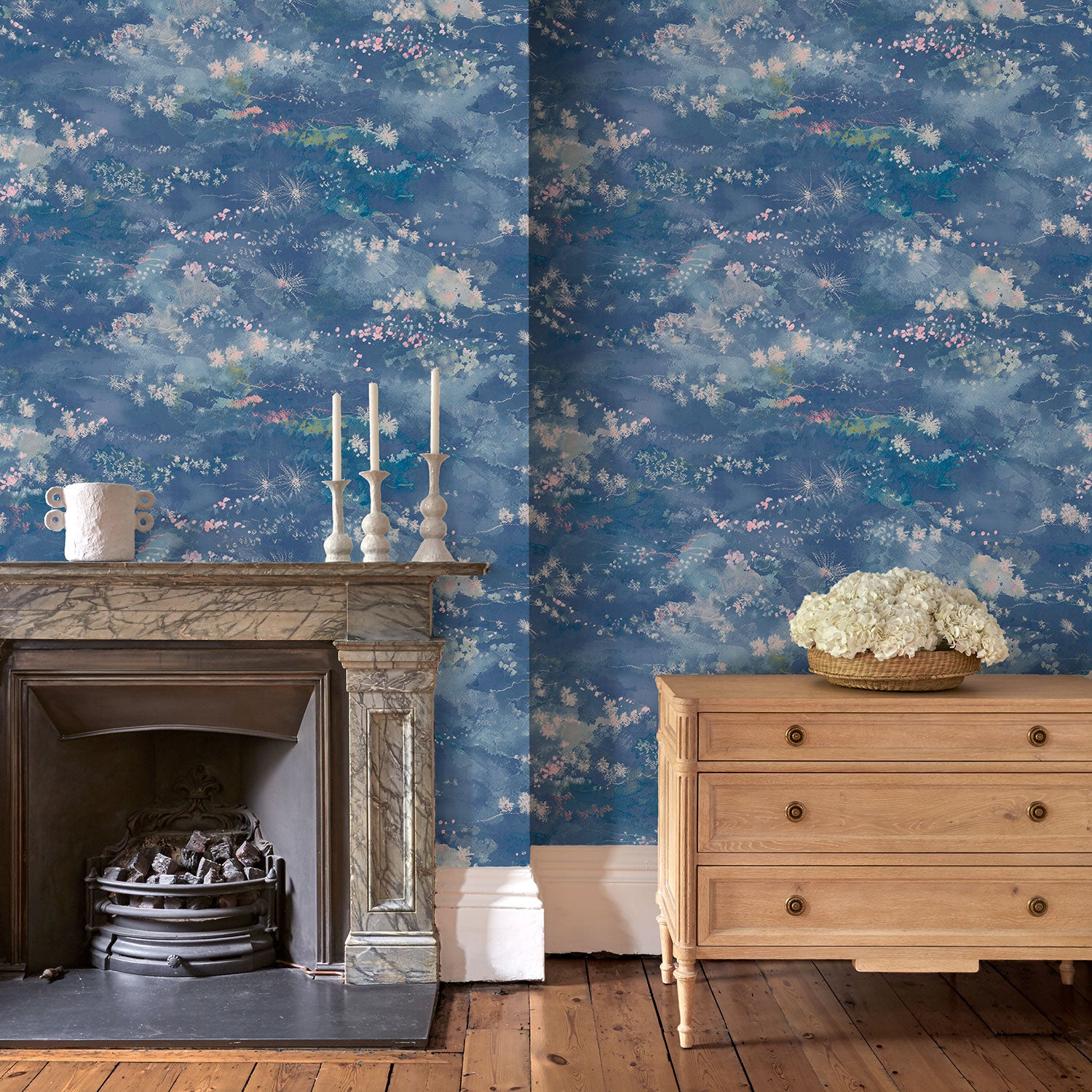 Sitting room featuring a painterly-style blue wallpaper.