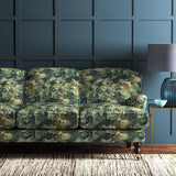 Sofa covered in a printed velvet fabric featuring a classic oak leaf design in green.