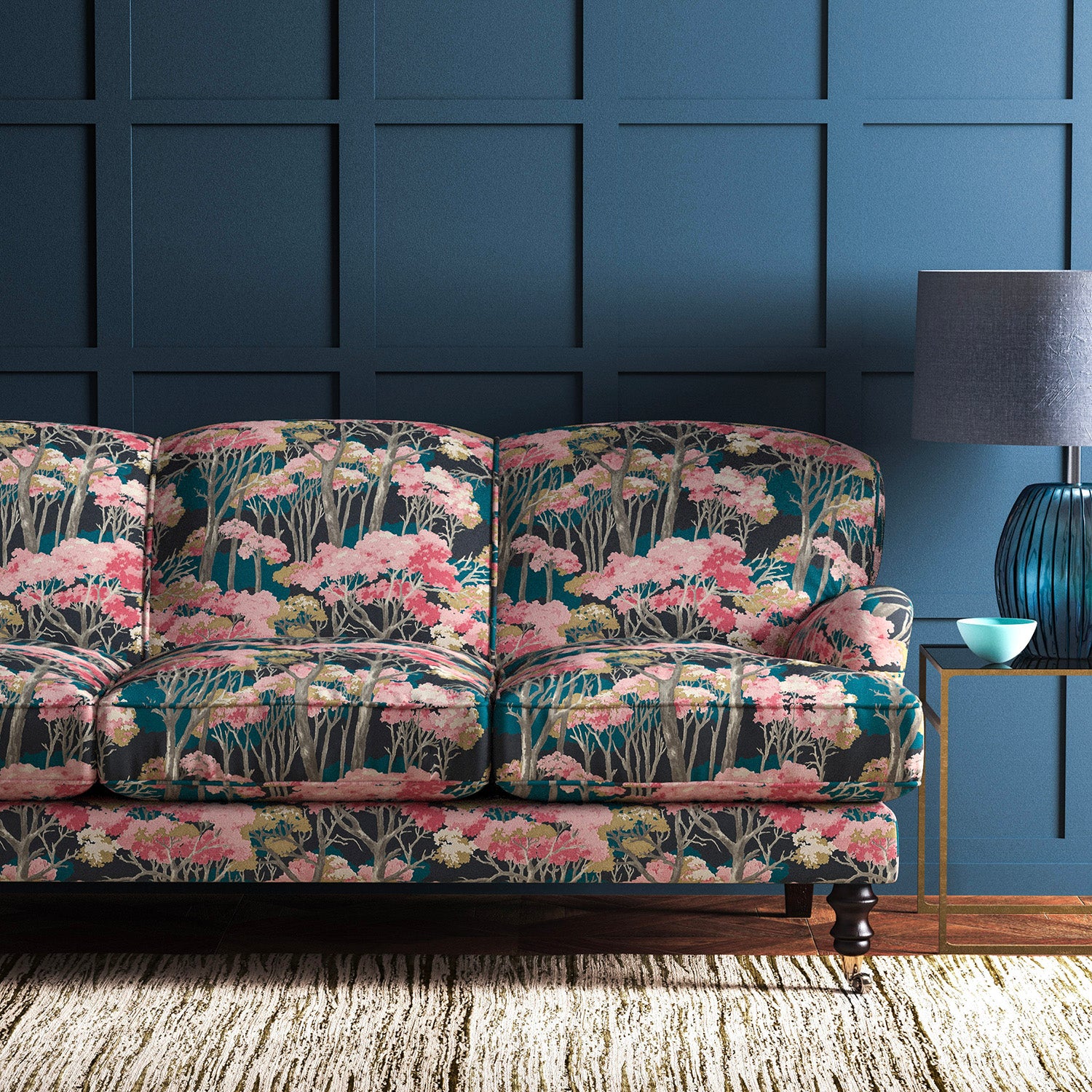 Sofa covered in a printed velvet upholstery fabric showcasing a pink Japanese tree design.