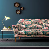 Sofa covered in a printed velvet upholstery fabric showcasing a pink Japanese tree design.