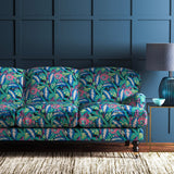 Sofa covered in a floral-style printed velvet fabric in blues and greens.