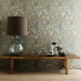Sitting room with a tropical wallpaper in a smart neutral showcasing beautiful botanicals and butterflies.