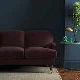 Sofa covered in a purple velvet upholstery fabric