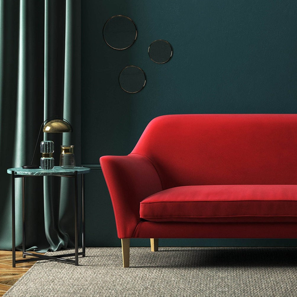 Sofa covered in a red velvet upholstery fabric 