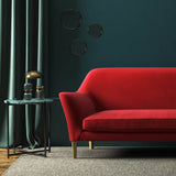 Sofa covered in a red velvet upholstery fabric 